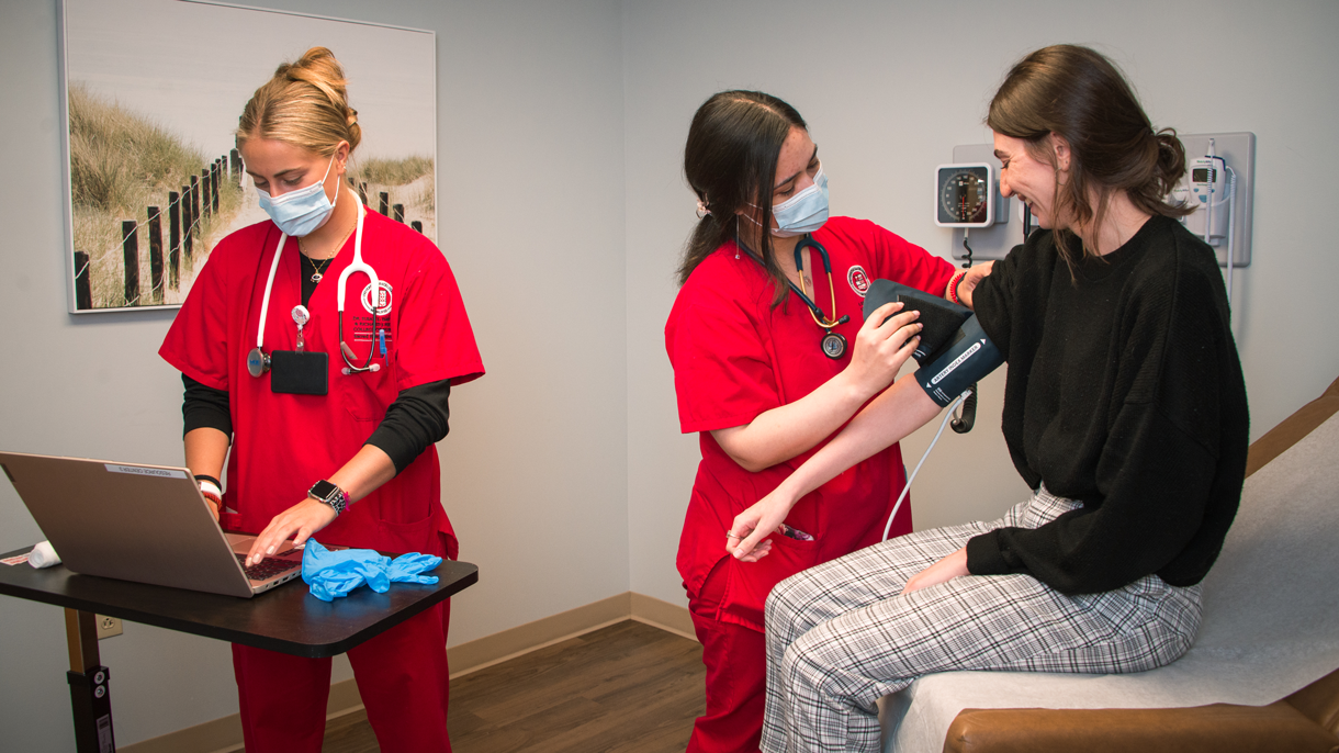Nursing students practicing with a patient