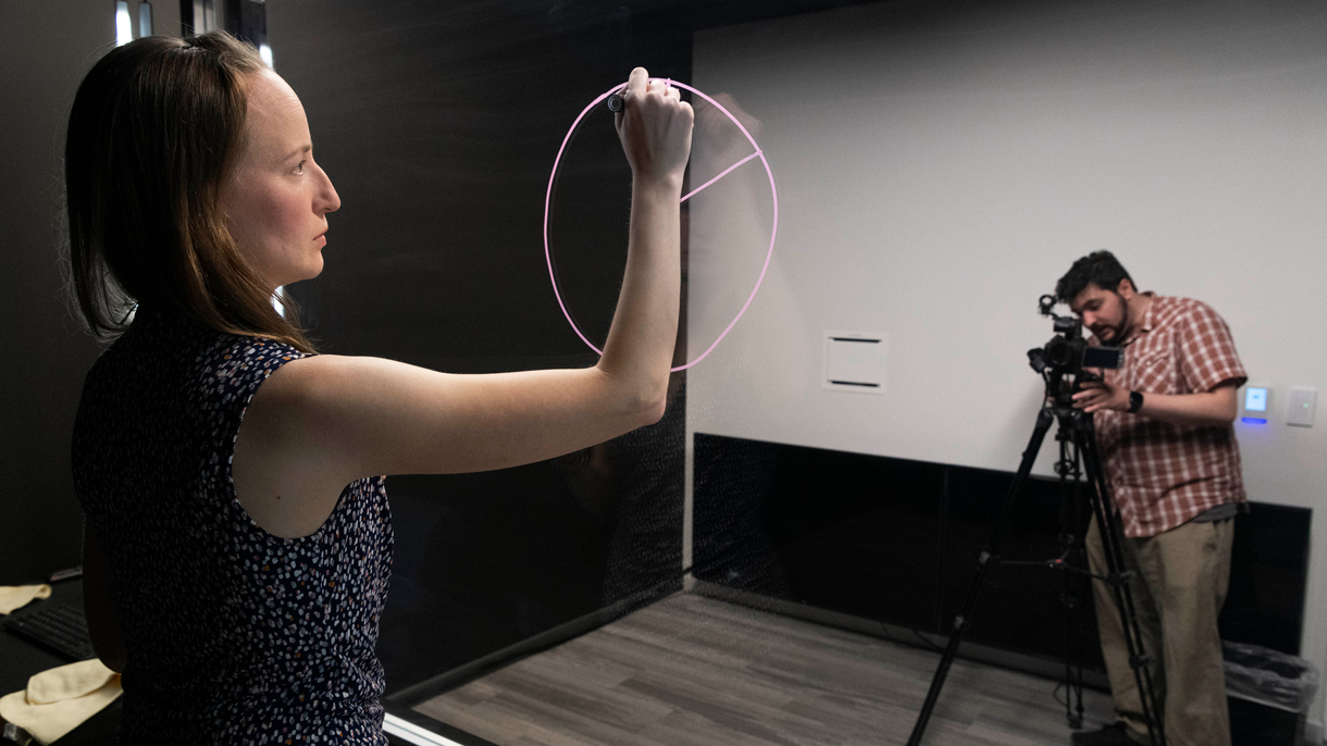 Woman drawing on a light board