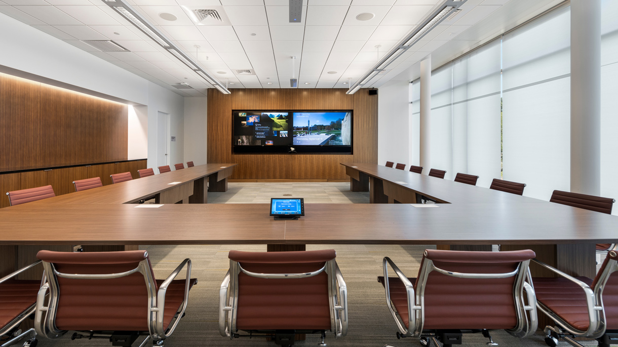 Room with a table, chairs and a tv screen