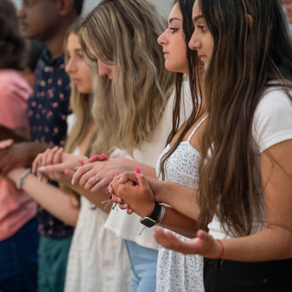 Students holding hands in the chapel