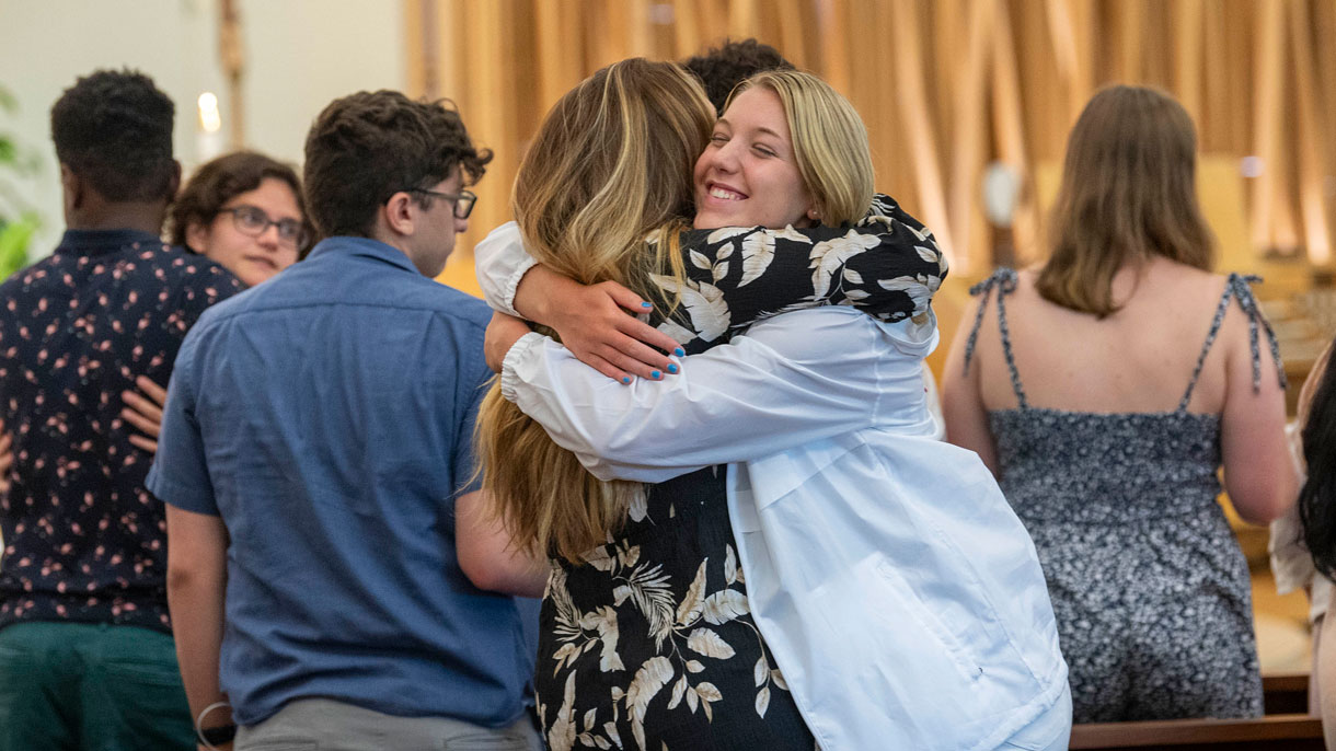 Students hugging and smiling in the Chapel
