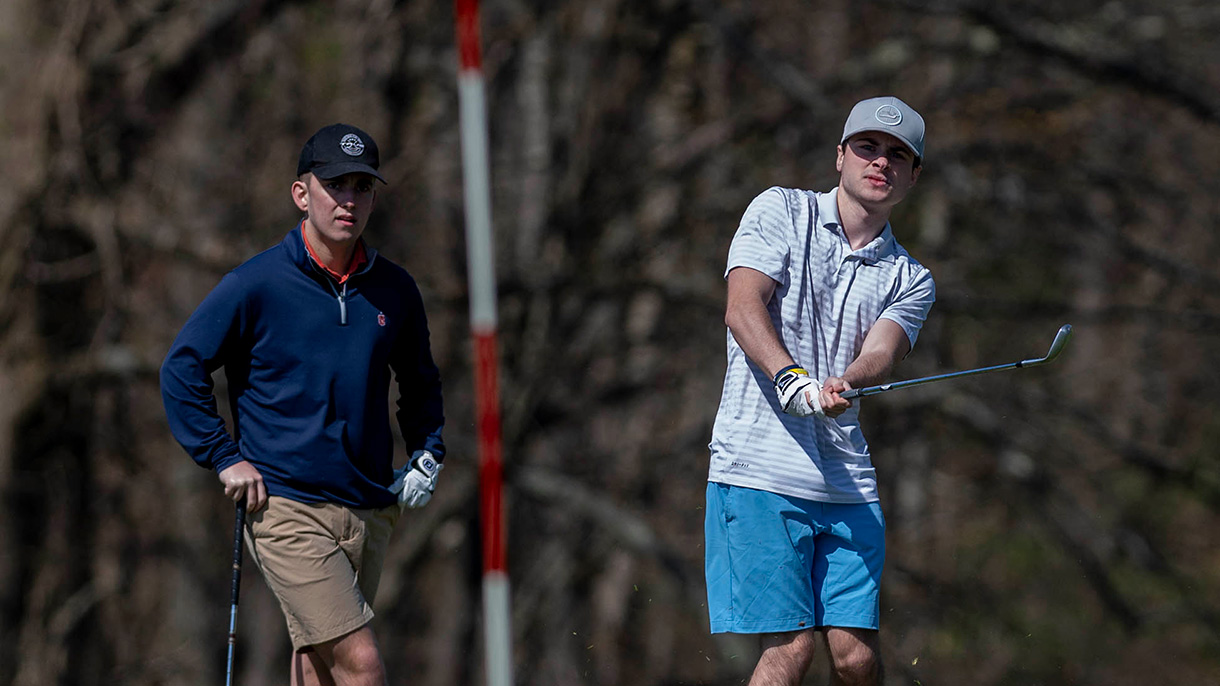 Golfers chip the ball onto the green.