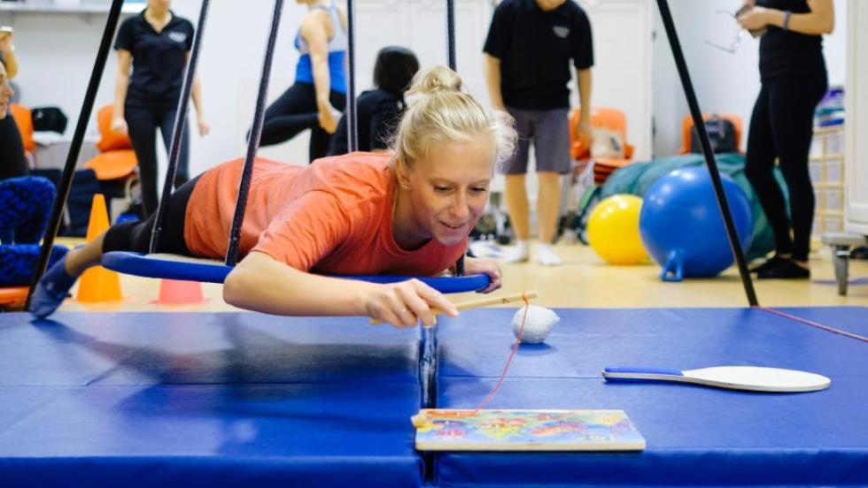 Student completing a puzzle on a swing