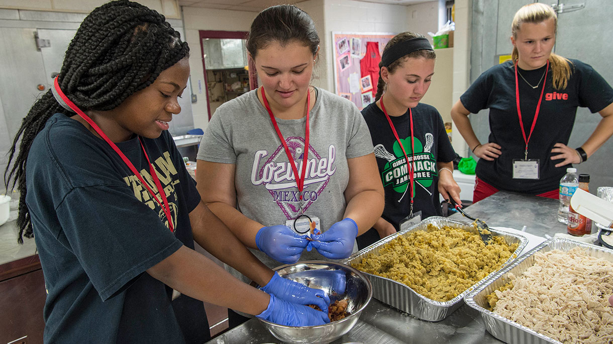 Student volunteers preparing dinner to serve at Thomas Merton Center