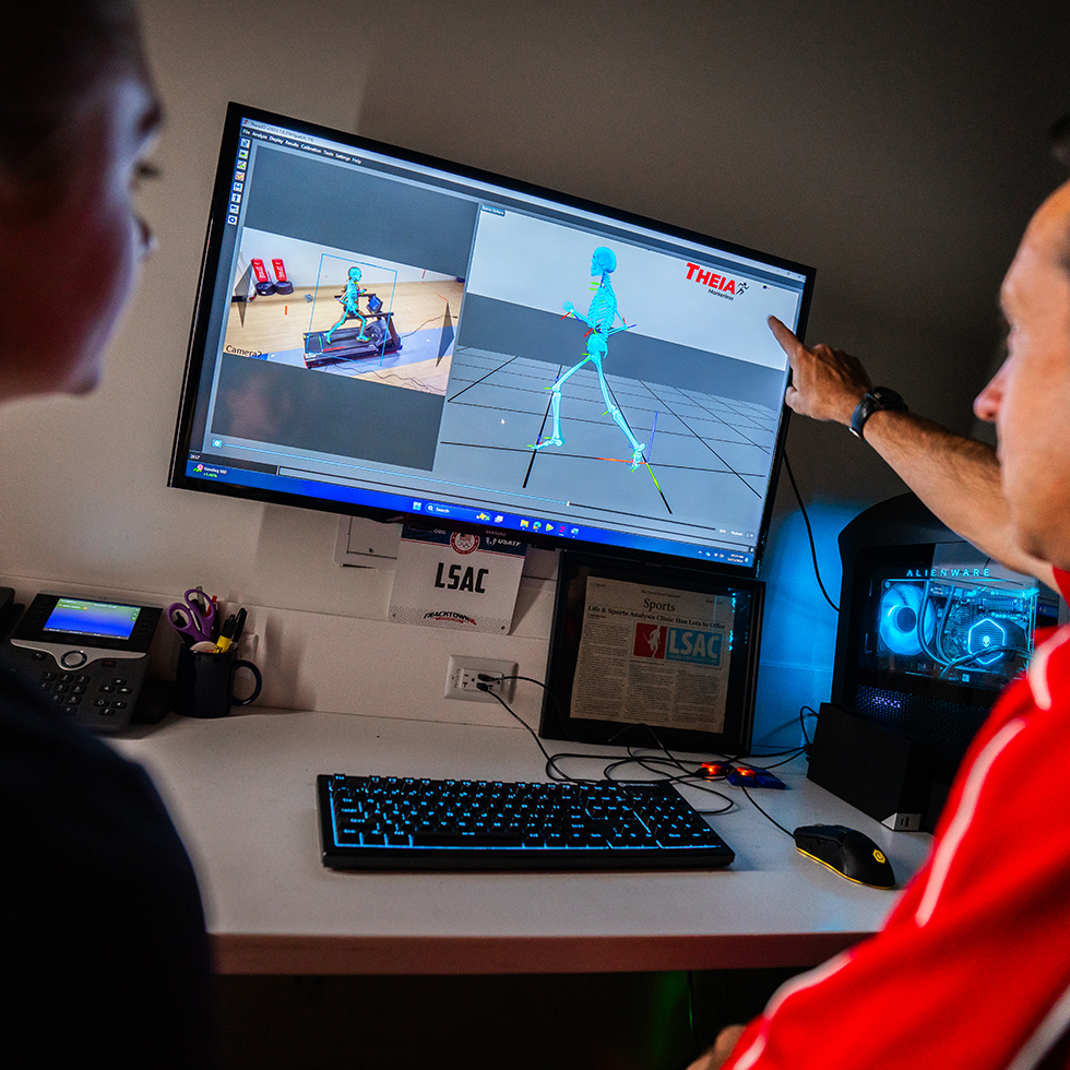an exercise scientist looks at gait results with a student