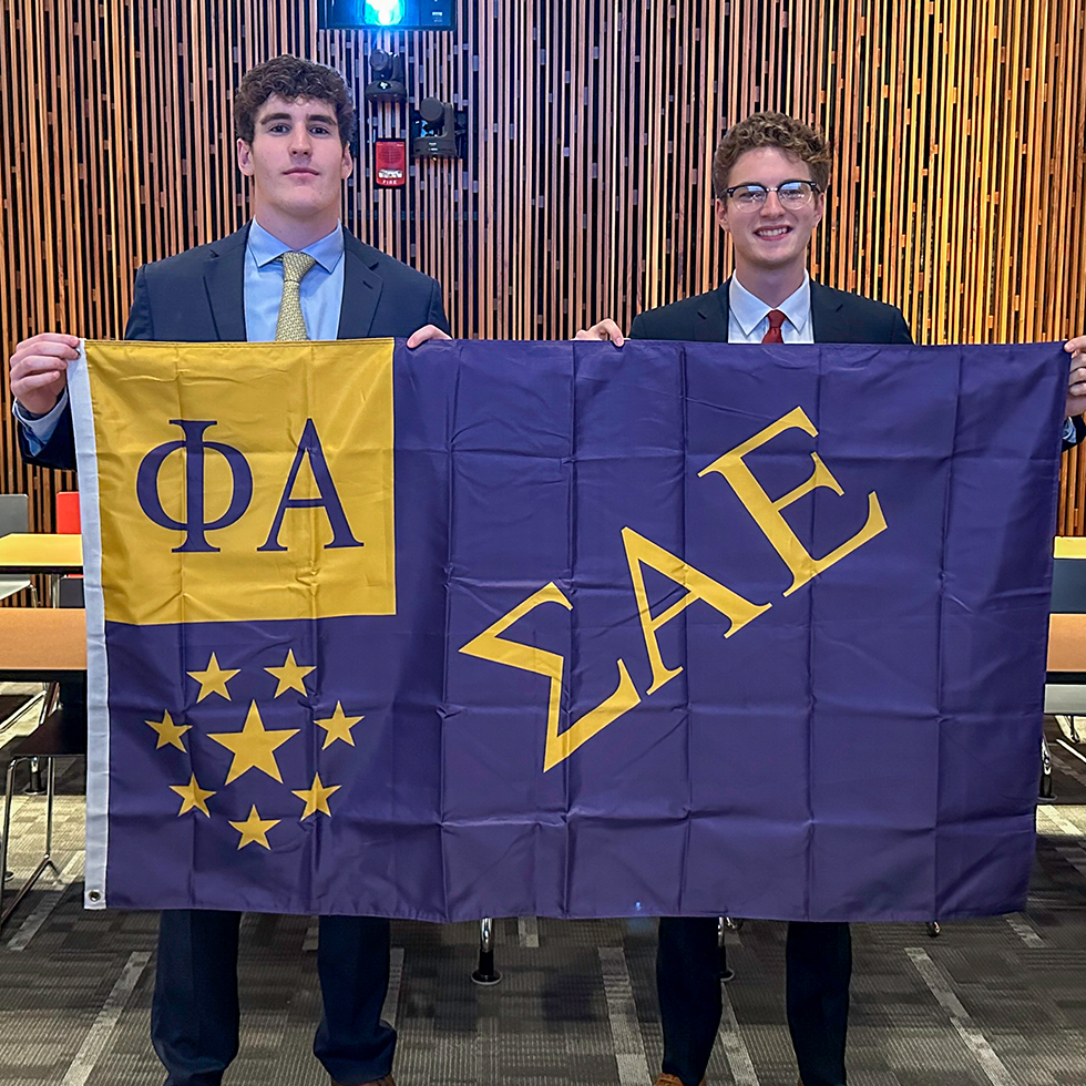 two men holding a sigma alpha epsilon flag