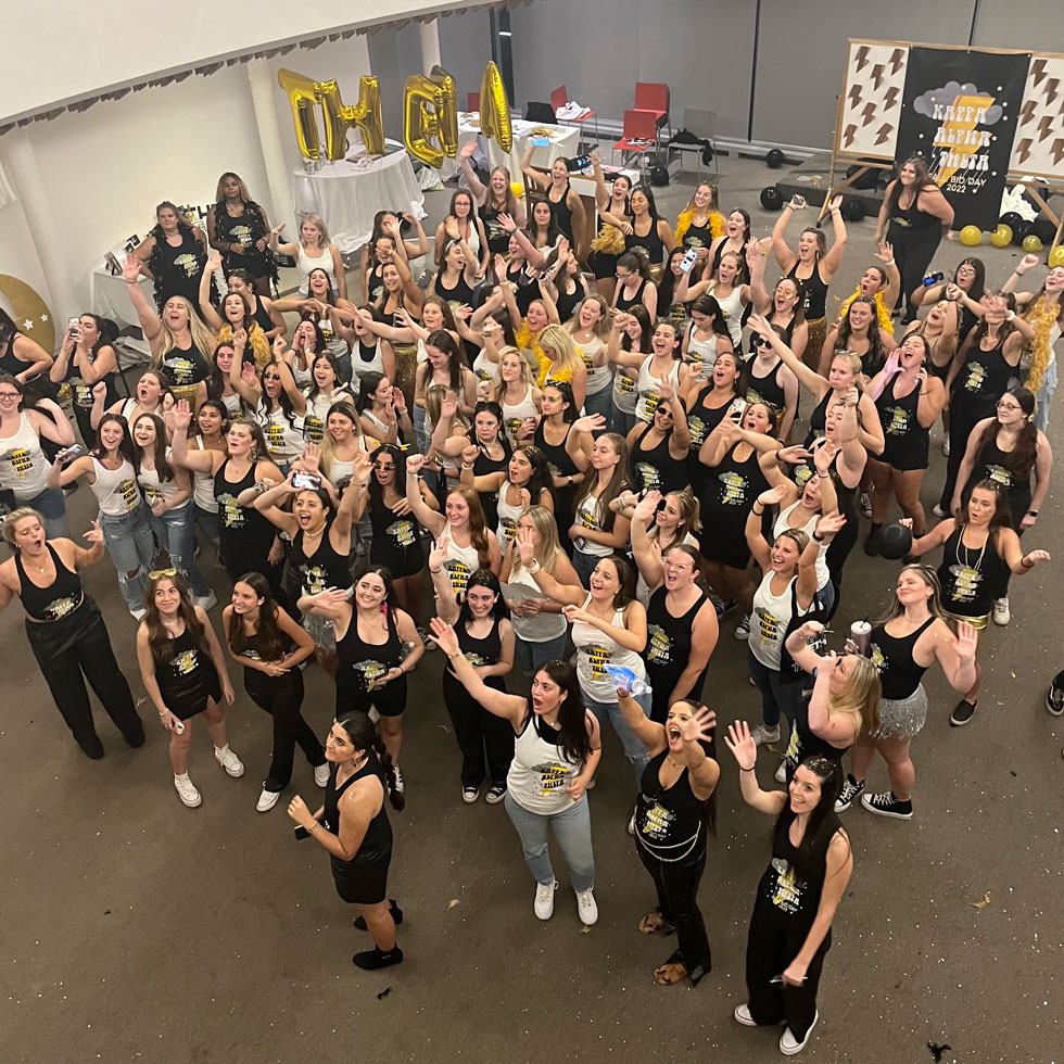 Members of Kappa Alpha Theta cheering during Bid Day. Black and gold theme