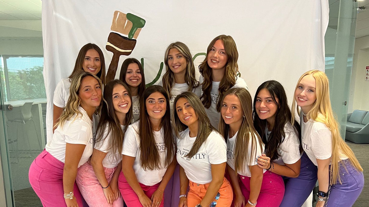 Members of Kappa Delta at a sisterhood event, wearing bright colored jeans and white shirts