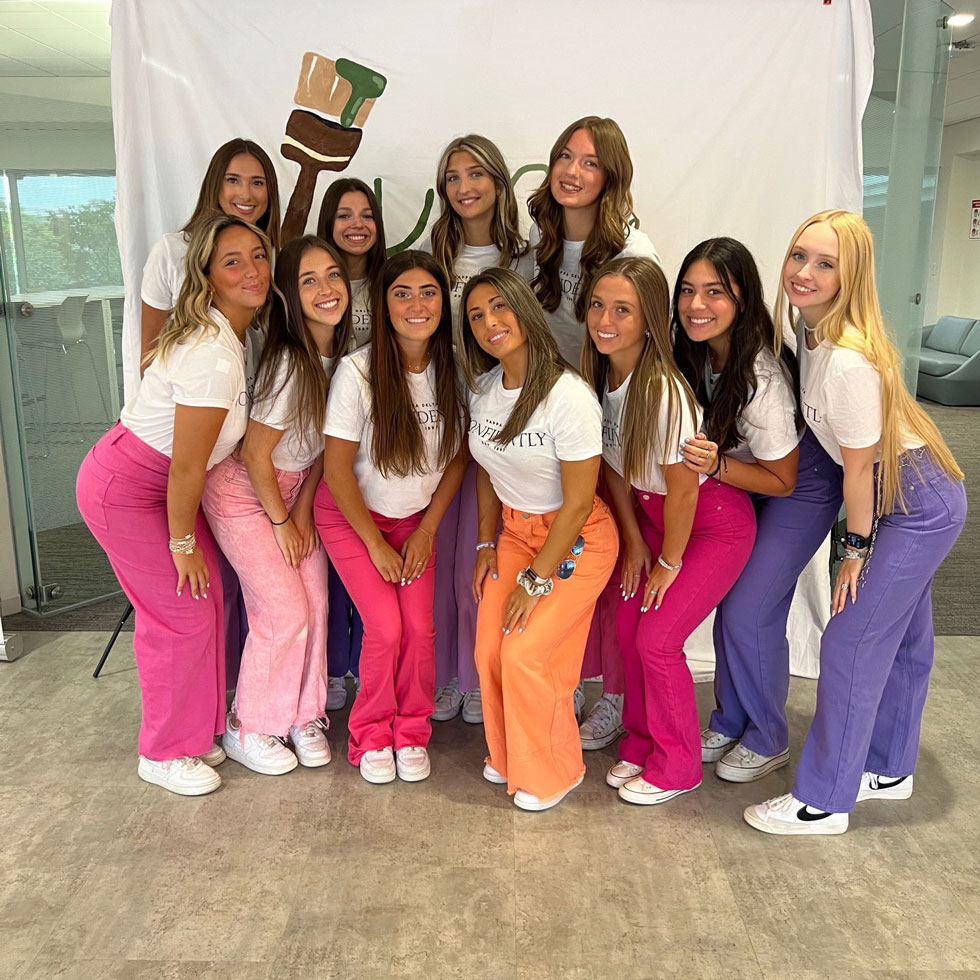 Members of Kappa Delta at a sisterhood event, wearing bright colored jeans and white shirts
