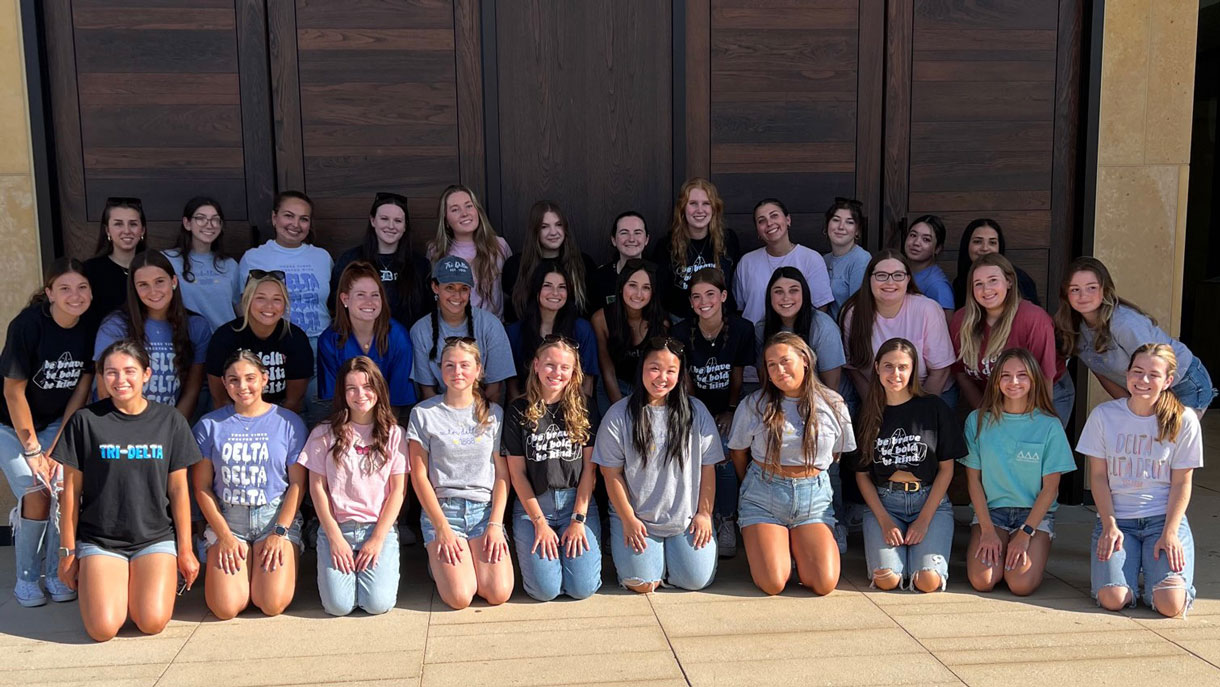 Members of Tri Delta posing for a photo in front of the chapel doors on main campus