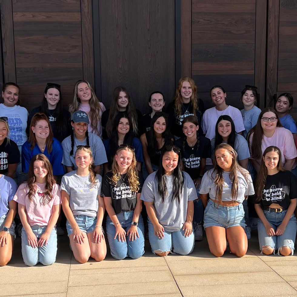 Members of Tri Delta posing for a photo in front of the chapel doors on main campus