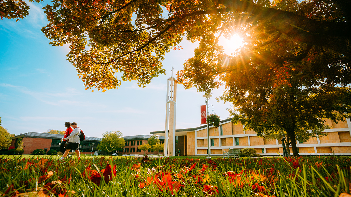 two college students walking on a campus quad in fall