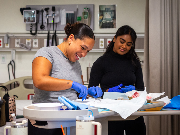Students learning how to suture in nursing lab