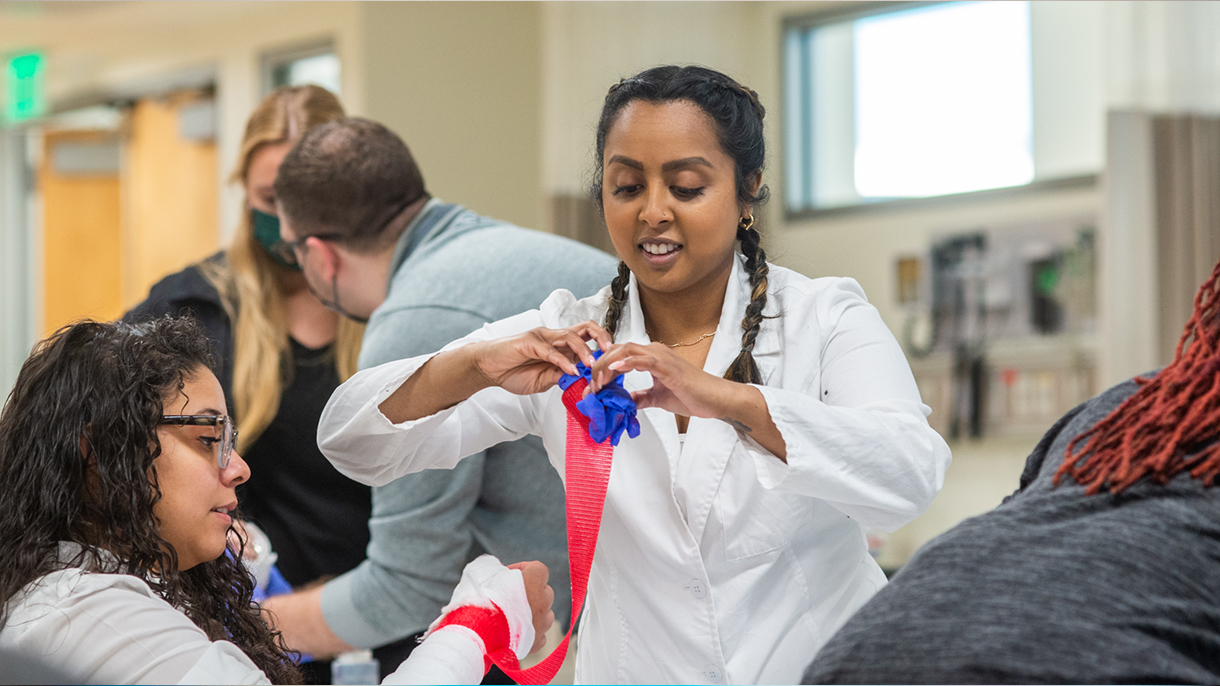 nursing student wraps an arm with a bandage
