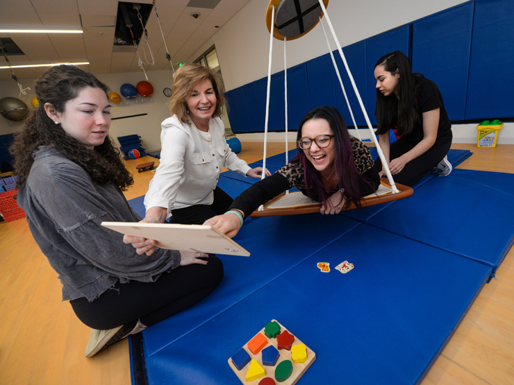 Students and professor using tools in pediatric lab