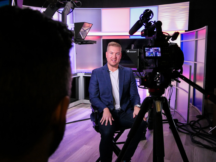 Student filming someone in studio