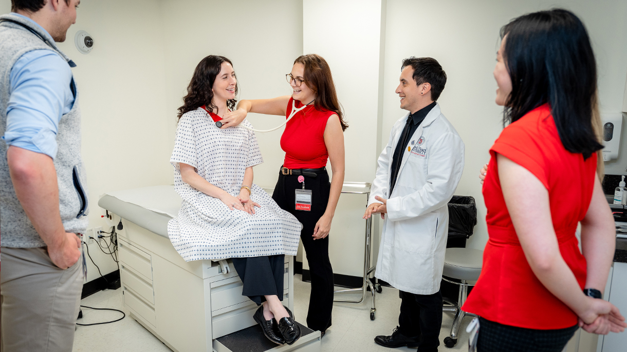 physician assistant student checking vitals on a classmate in an exam room