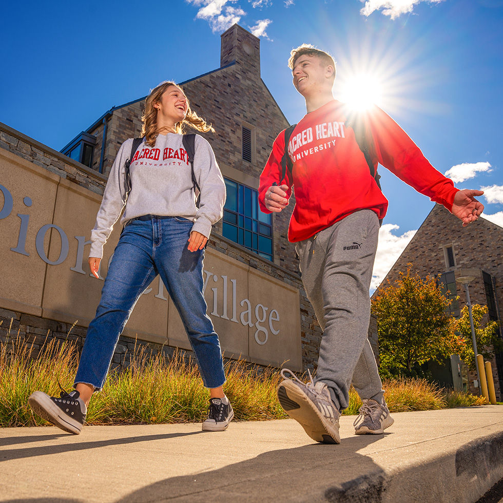 two college students walking together in sunshine