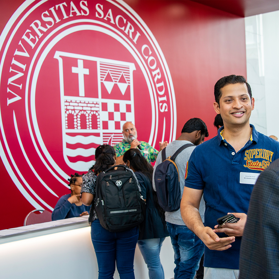 A person smiling at a college open house event