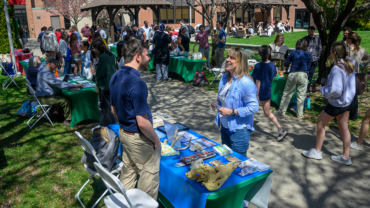 earth day fair showing people and vendor tables on a patio
