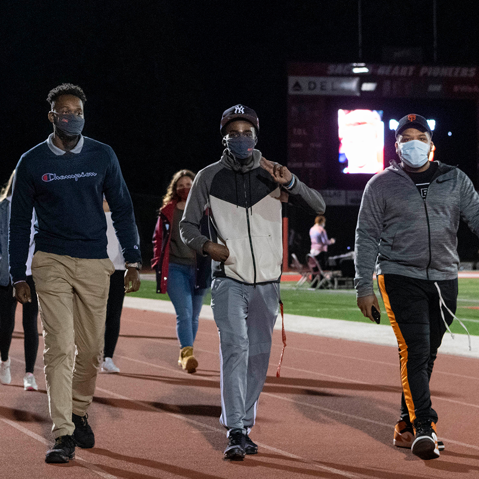 Students walk around the Campus Field track as part of a suicide prevention walk on September 20, 2020.