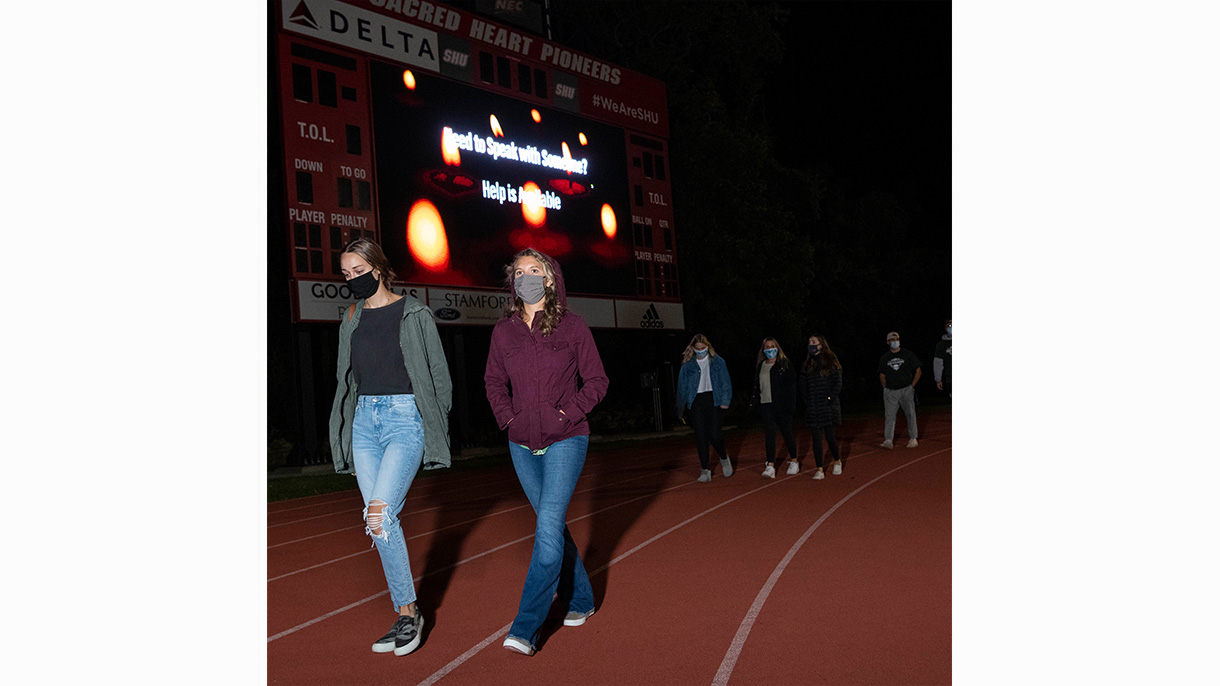 Students walk around the Campus Field track as part of a suicide prevention walk on September 20, 2020.