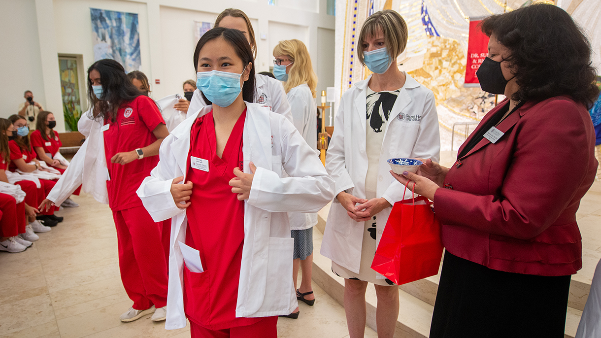 nursing student putting on a white coat