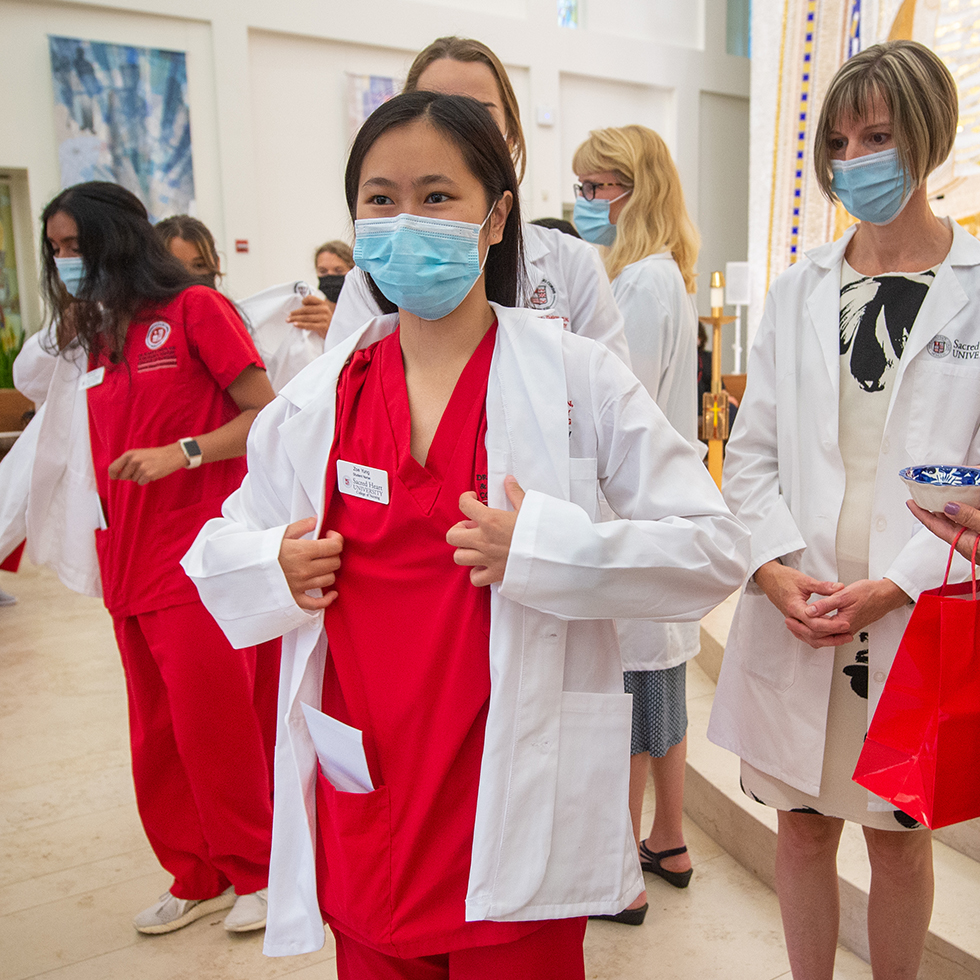 nursing student putting on a white coat