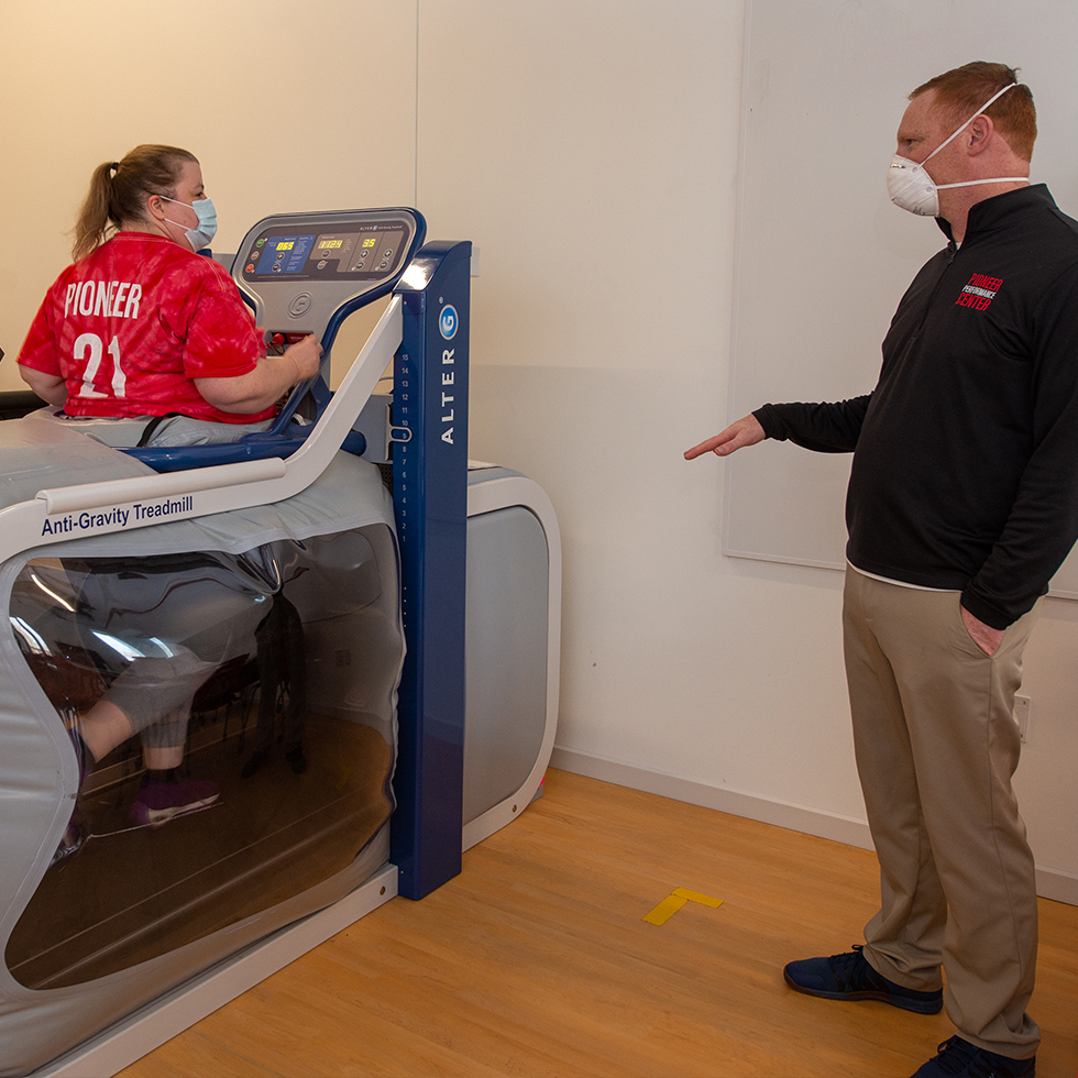 Woman being instructed by an exercise scientist on an anti-gravity treadmill
