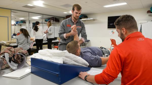 college student assesses client in neuro-cardio lab