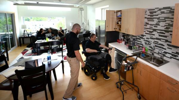 person in wheelchair doing occupational therapy in a kitchen