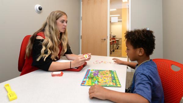 college student works with child in a speech lab