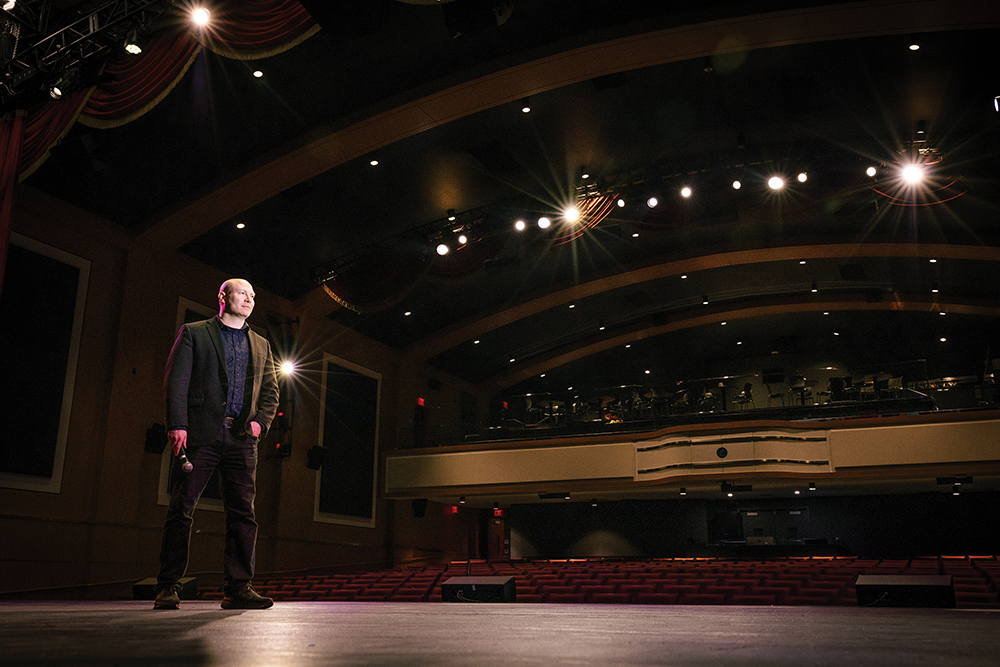 Matt Oestreicher on stage in an empty theater