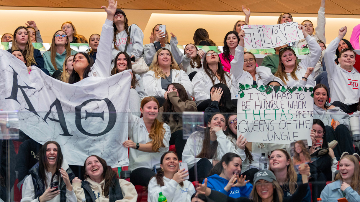 Crowd of sorority sisters holding up signs