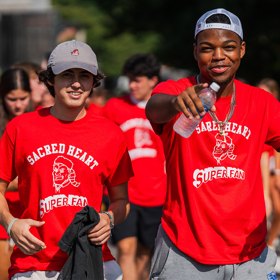 two people in SHU-branded t-shirts posing for a photo