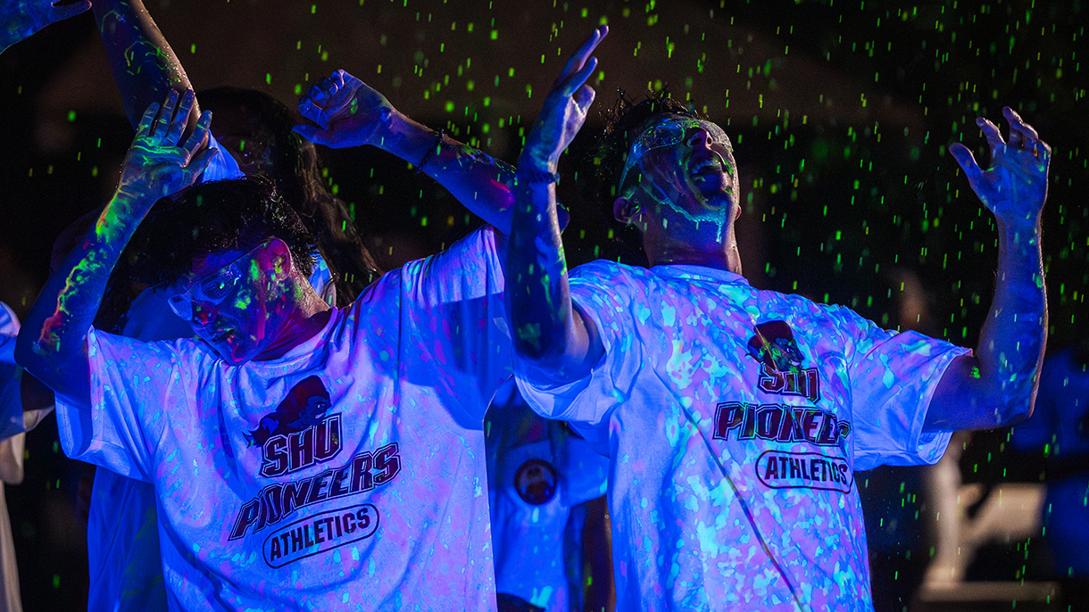 two people dancing at night covered in glow-in-the-dark paint splatter