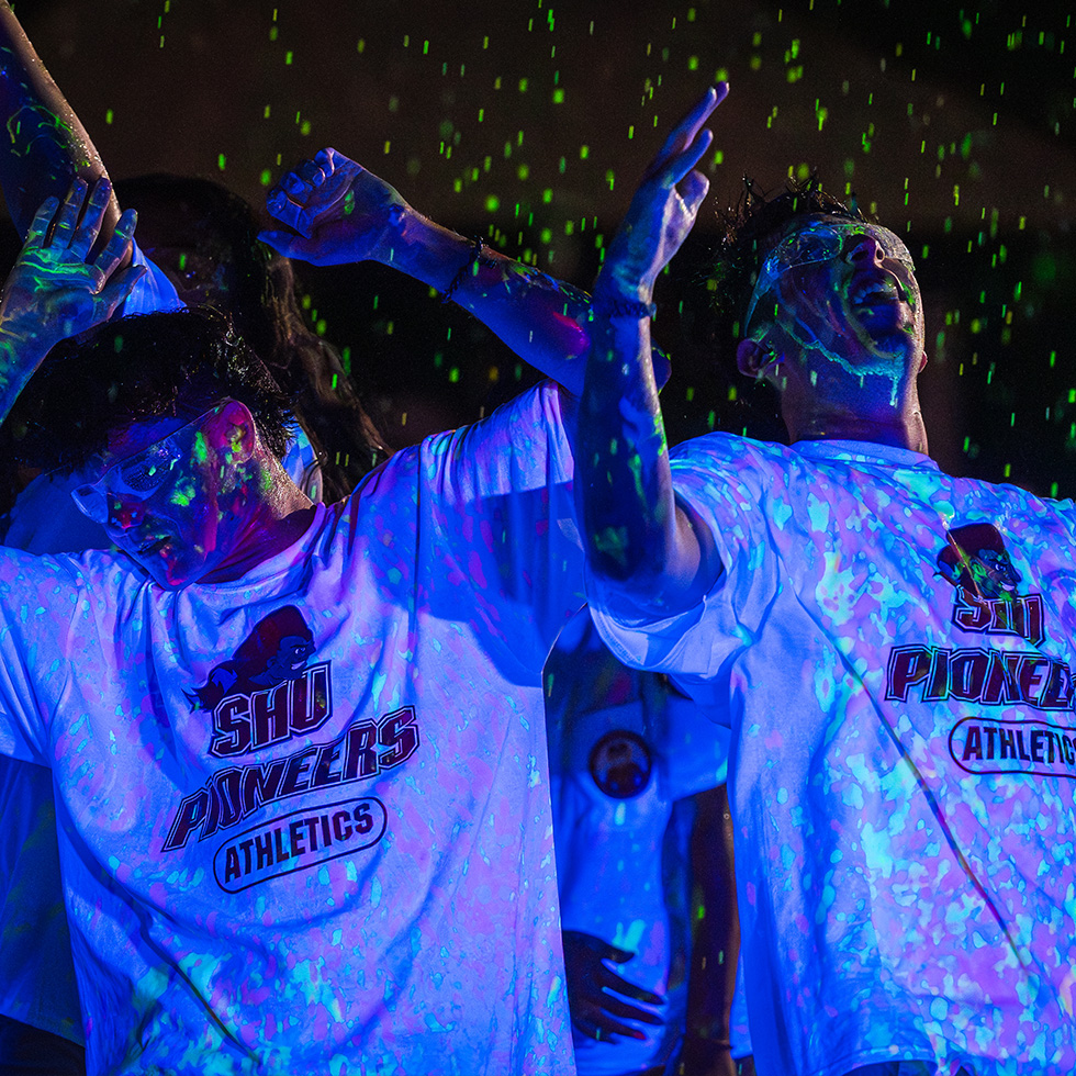 two people dancing at night covered in glow-in-the-dark paint splatter