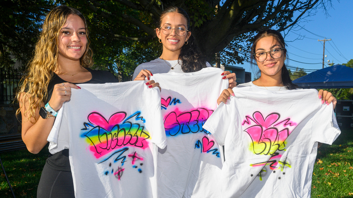 Students holding up t-shirts made at the SHU carnival