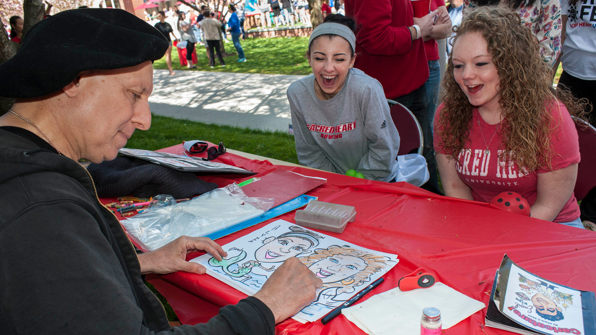 Two students getting their caricature drawn