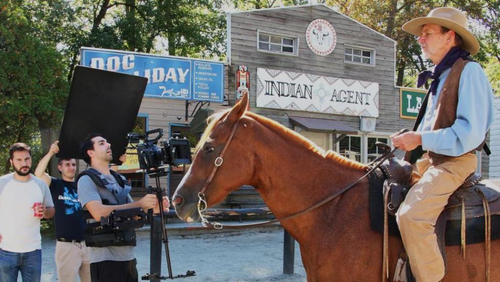 Students filming a man on a horse