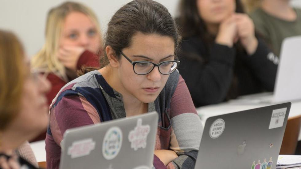 Woman in class looking at laptop