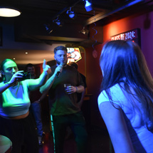 Students singing karaoke in Reds