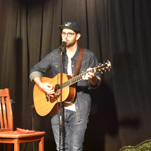 Drakeford singing and playing guitar