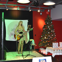 Gracie Yates singing and playing guitar on stage