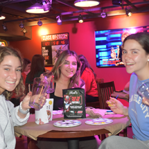 Students painting pint glasses in Reds