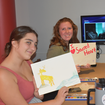 Students holding up their artwork