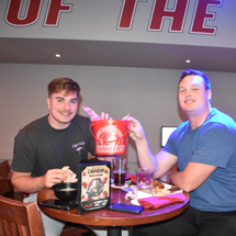 Students holding up a wing bucket