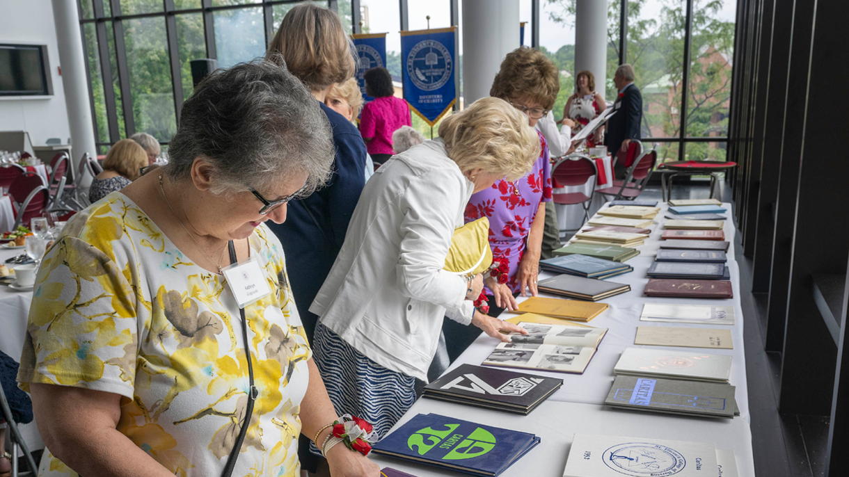 Alumni reading old Sacred Heart yearbooks
