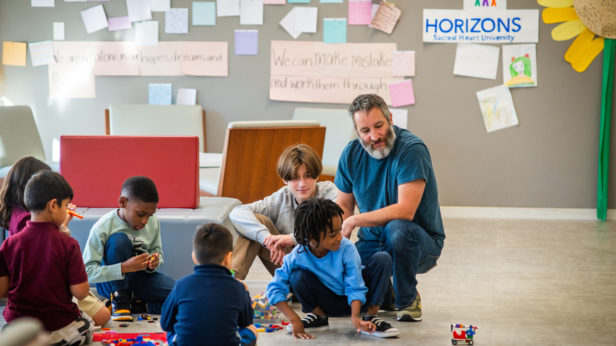 Teacher with students playing on floor