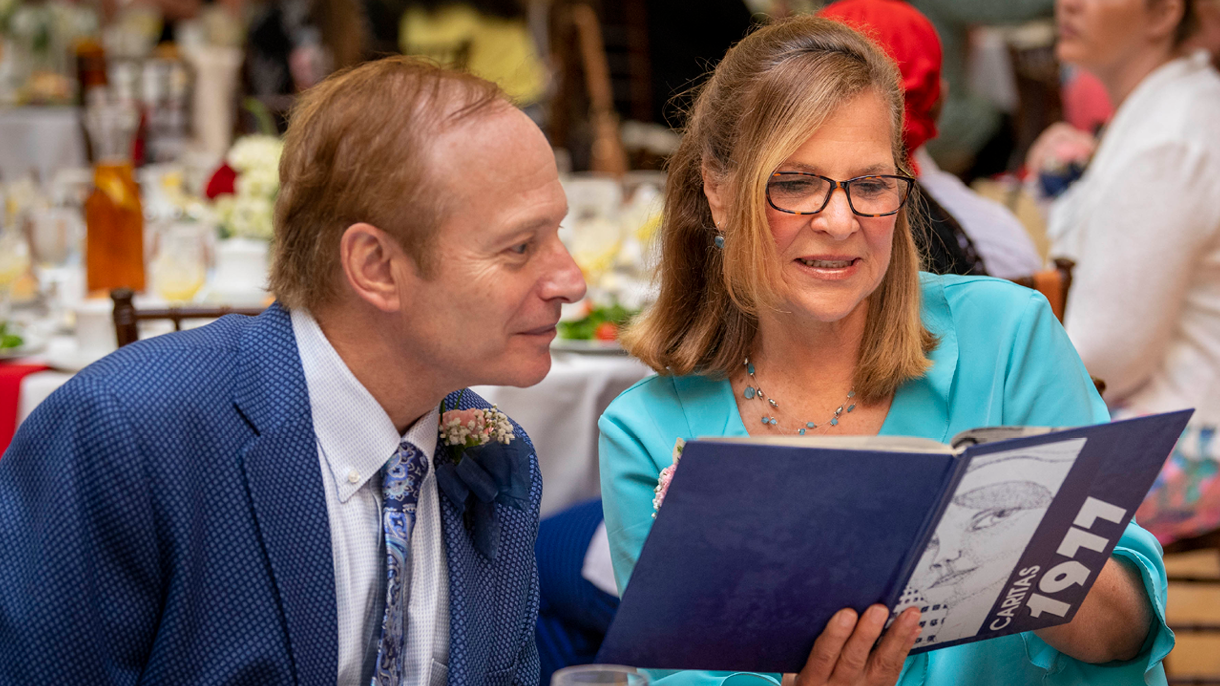 Two people reading old yearbook